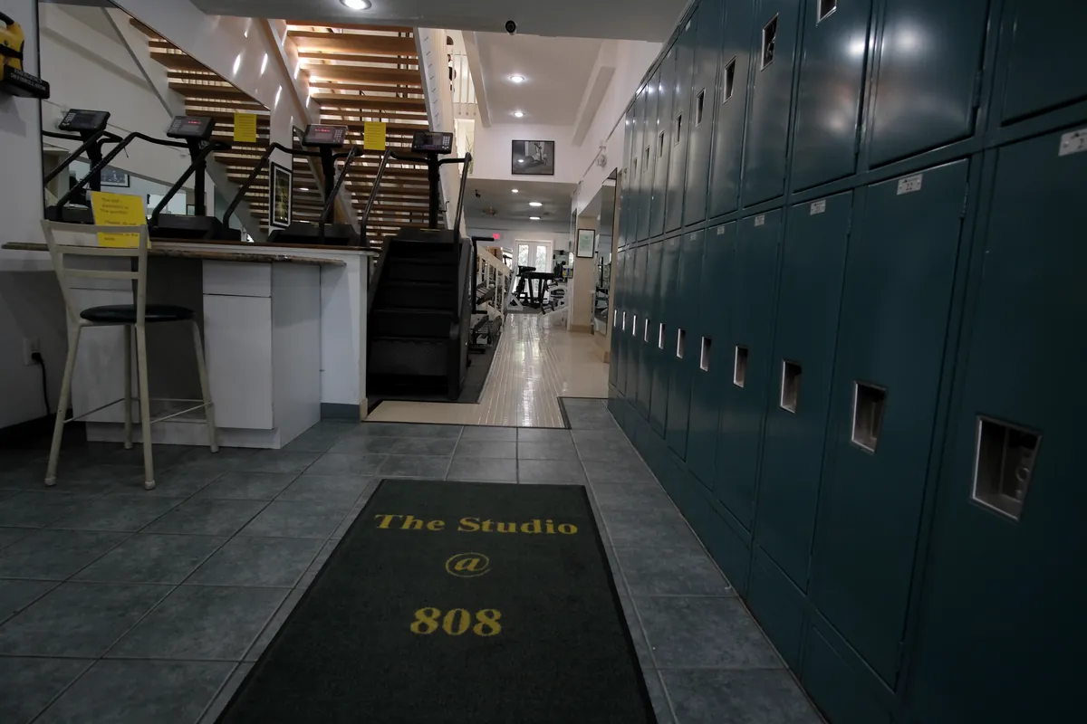 The entrance hall at The Studio @ 808, with member lockers and a doormat printed with the club's name