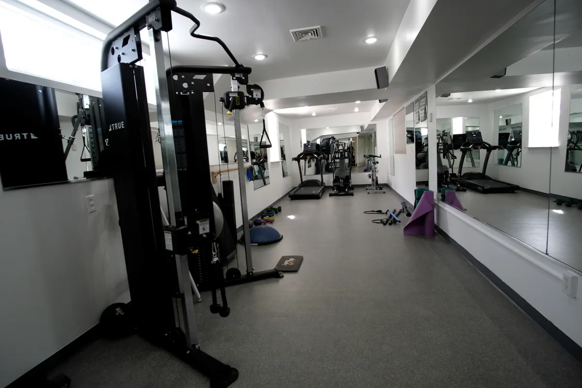 The women's room with a cable machine, mirrors and mats