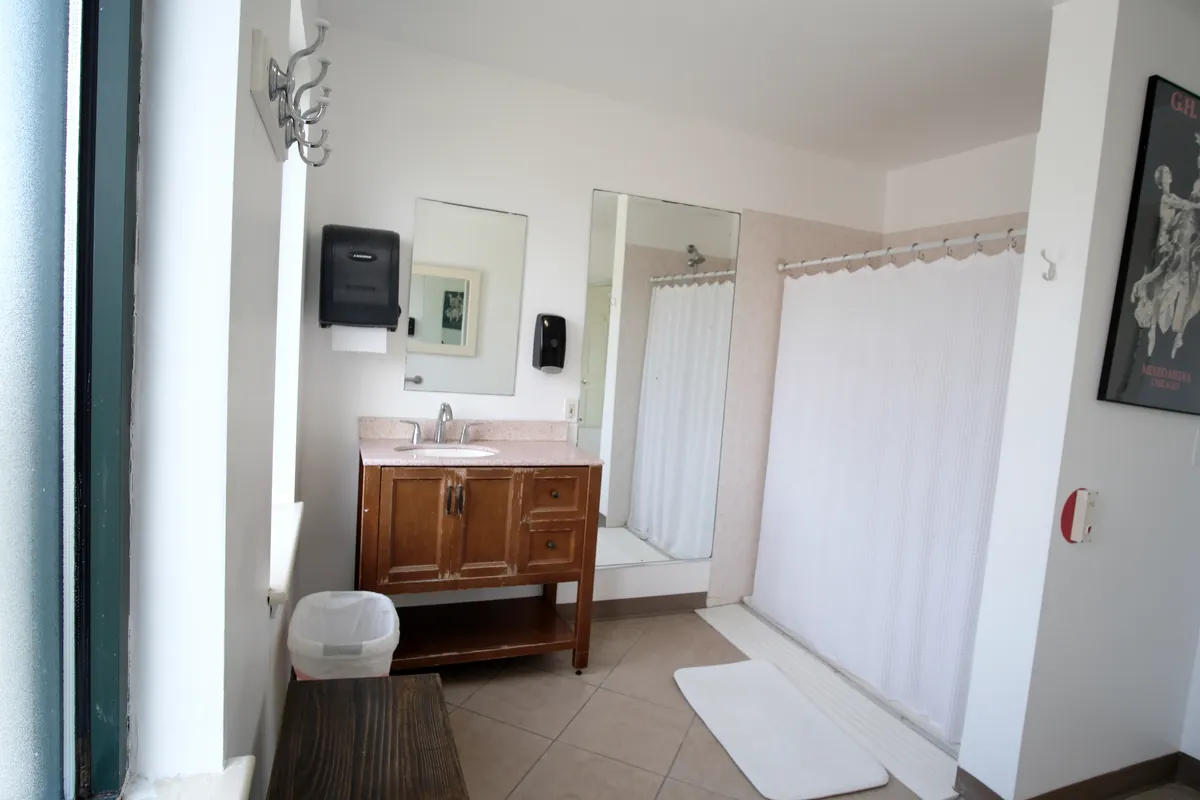 A changing room with a vanity and shower